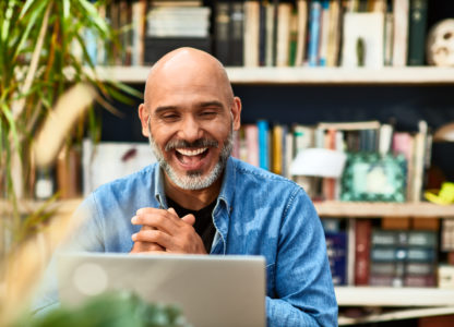 Mature man laughing and smiling on video conference